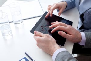 Unrecognizable business colleagues working together and using a digital tablet